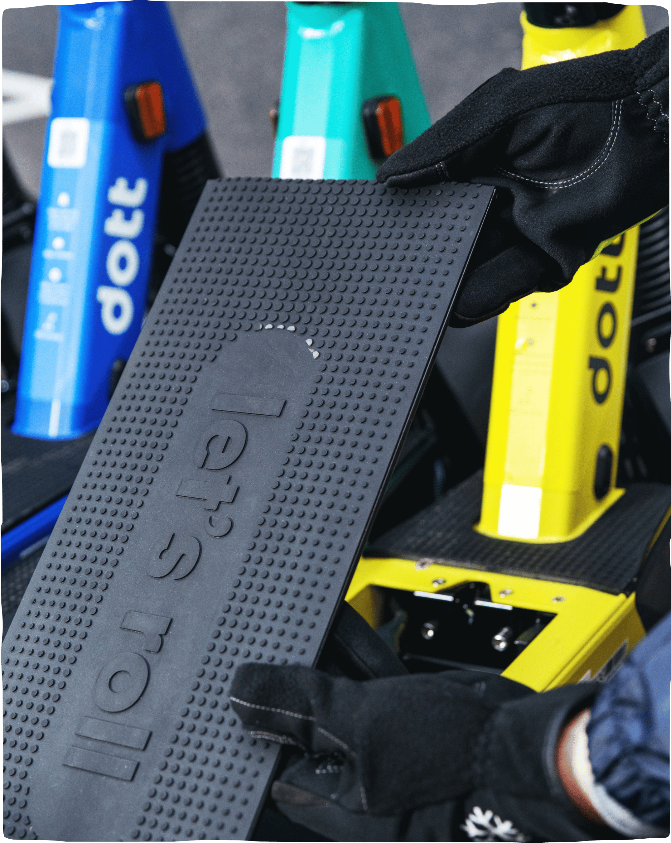 A close-up shot of a person doing maintenance on a scooter deck that says ‘let’s roll’.
