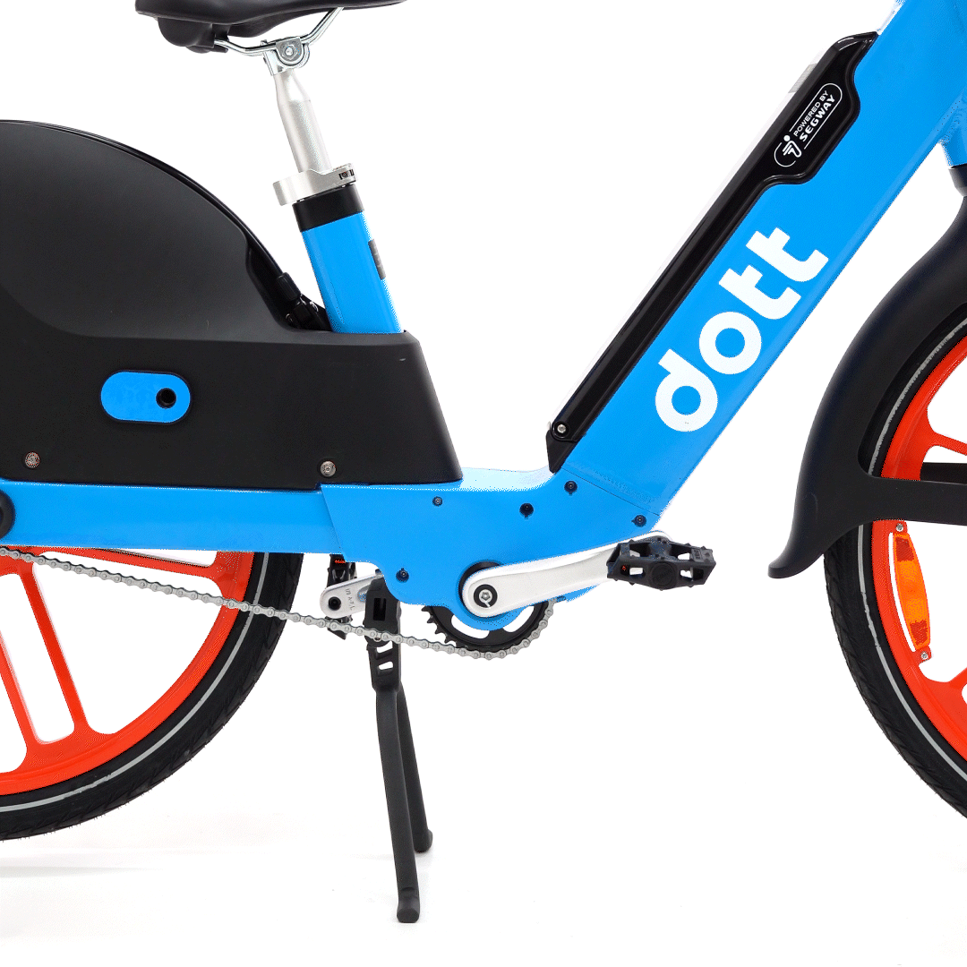 A GIF of a person rolling a bike forward off of its kickstand, with illustrated arrows moving right to show movement.